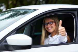 49026681 - woman driving his car and makes gesture with thumb up
